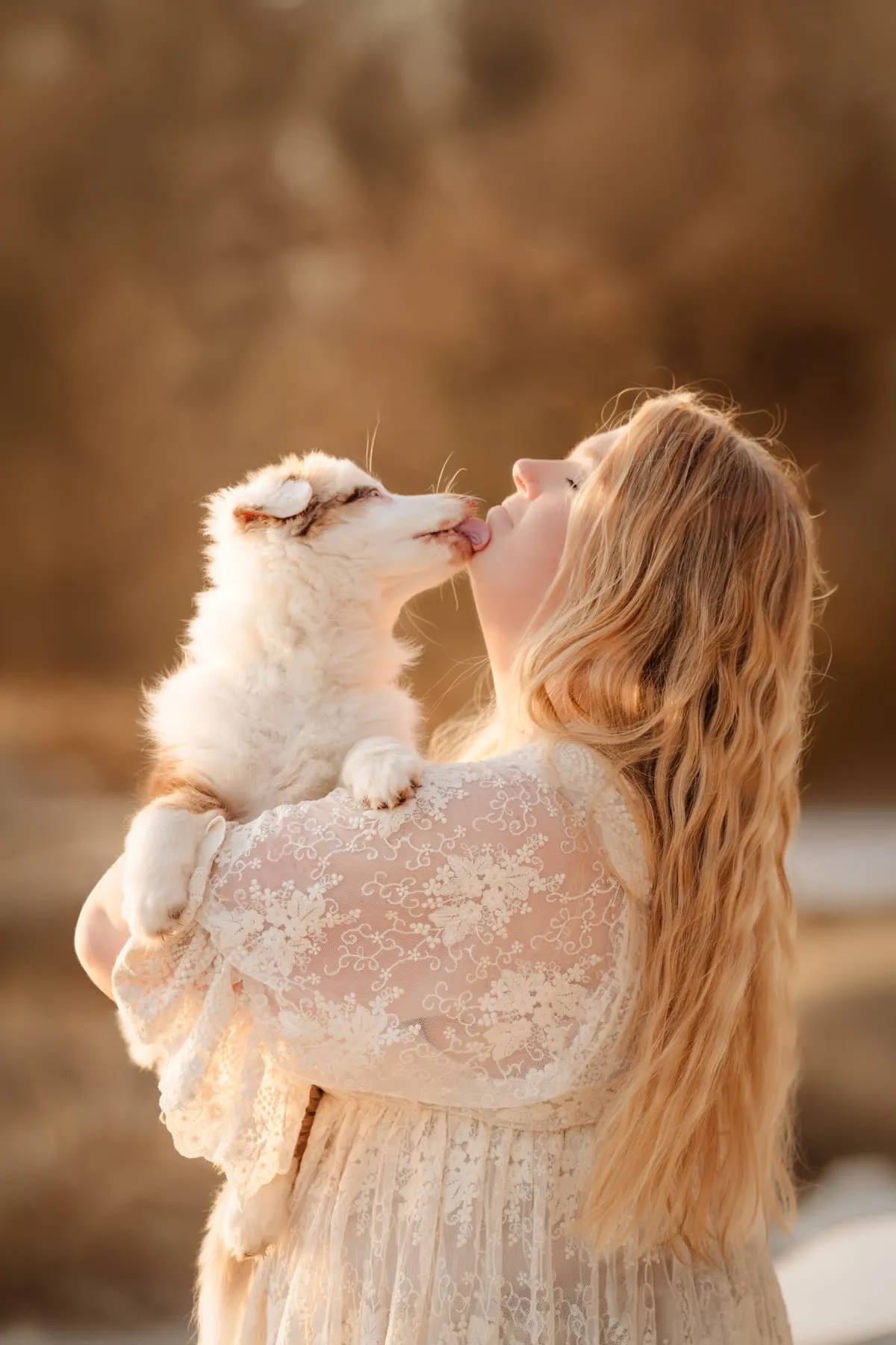 Coralie küsst einen jungen Hund, warmes Gegenlicht am Abend